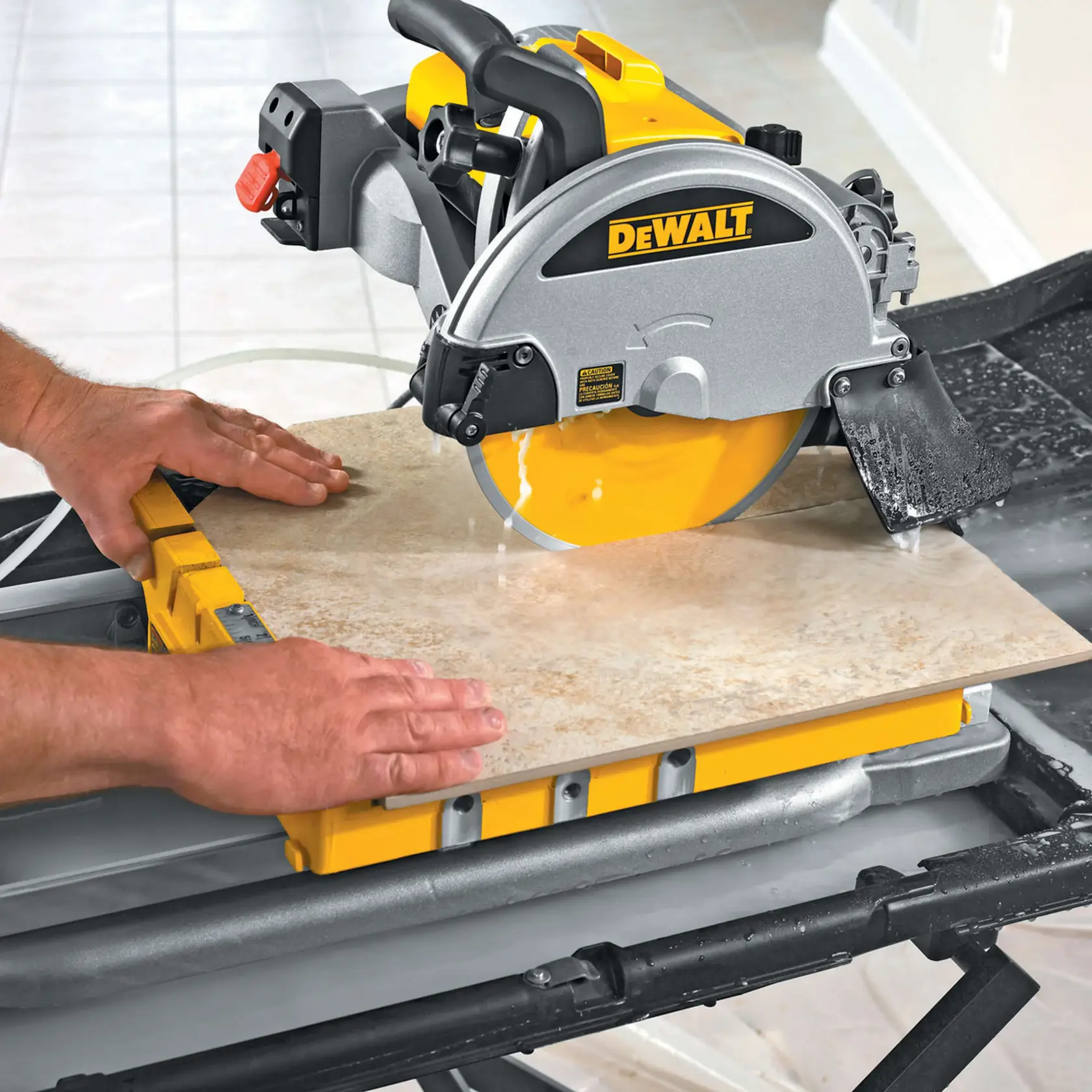 Une personne utilise une scie à carreaux DEWALT D24000 pour couper un carreau en céramique. La scie à carreaux est montée sur un support de travail et de l'eau est utilisée pour refroidir la lame pendant la coupe.