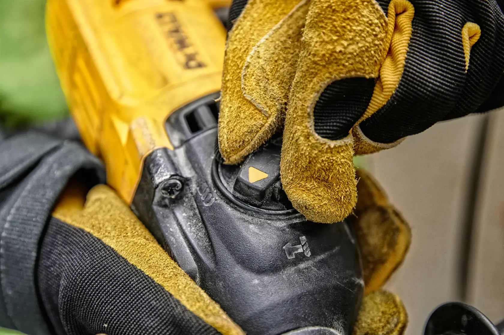 Vue rapprochée d’une main gantée réglant le sélecteur de mode sur un outil électrique DEWALT, montrant le corps jaune et noir de l’outil et le cadran de contrôle.