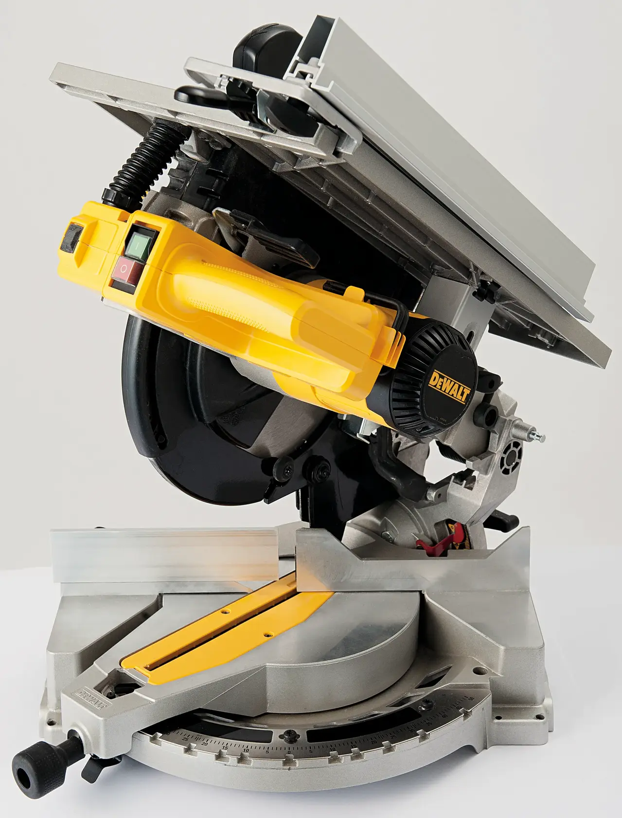 Scie à onglets combinée DEWALT D27113 avec poignée jaune et base argentée. La scie est inclinée, montrant la lame, le réglage de l'angle et la plateforme de coupe.