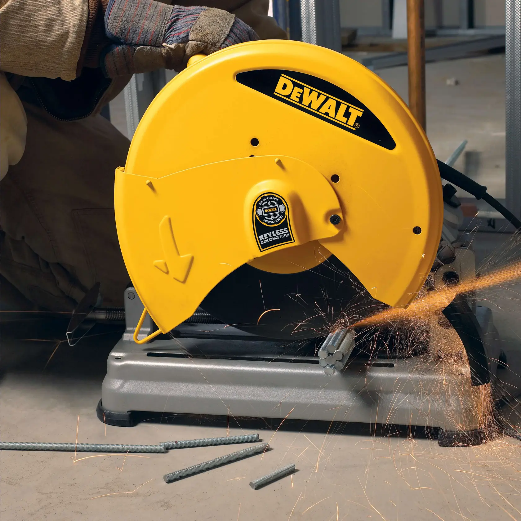 Une scie à métaux jaune DEWALT D28715 en cours d'utilisation, coupant des tiges métalliques et produisant des étincelles, utilisée par une personne portant des gants de protection.