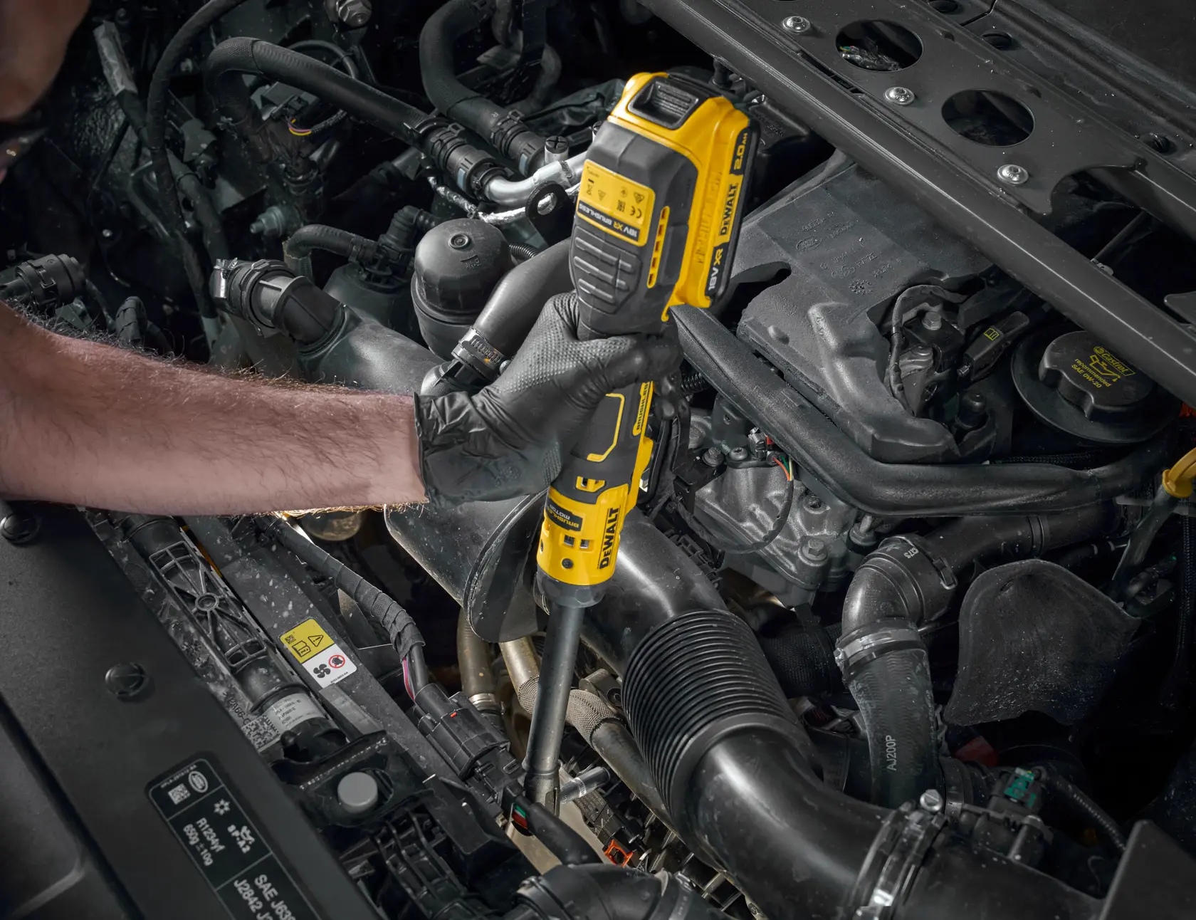 DEWALT DCF514EN-XJ et DCF514EN utilisés par une main gantée sur moteur. Catégorie photographie.