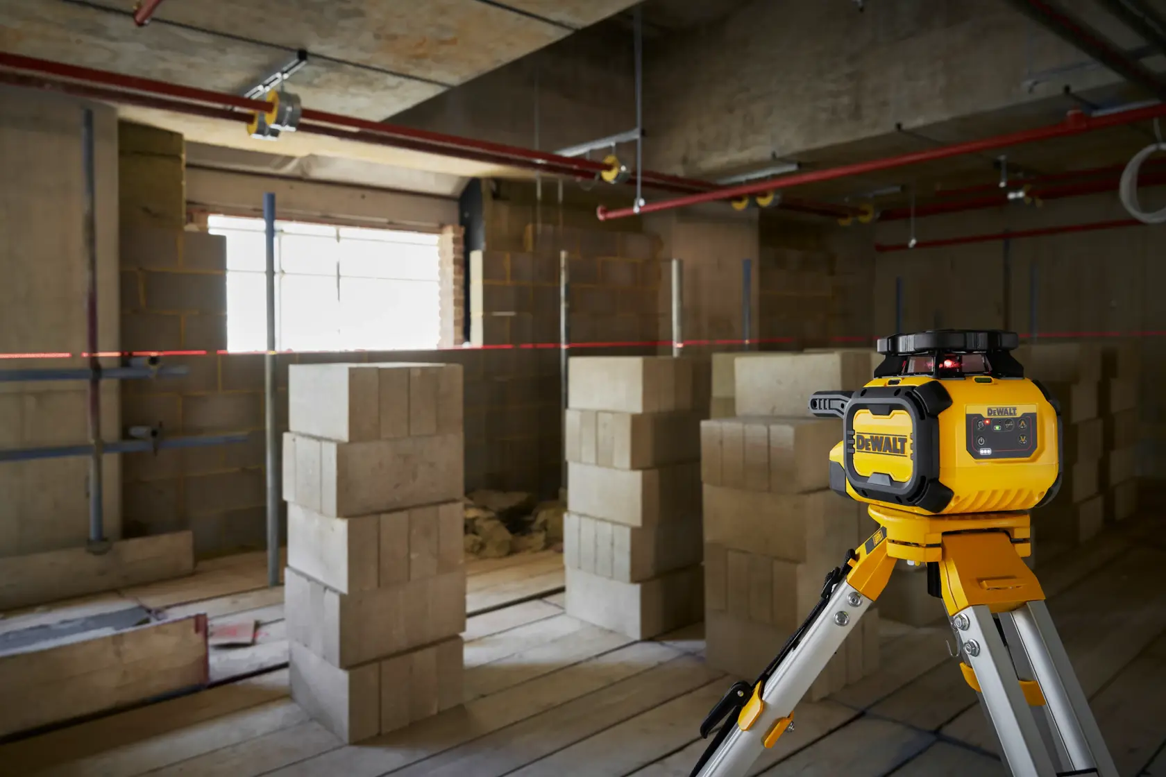 DEWALT DCLE15211R, DCLE15211R-QW niveau laser sur trépied sur site de construction avec blocs.