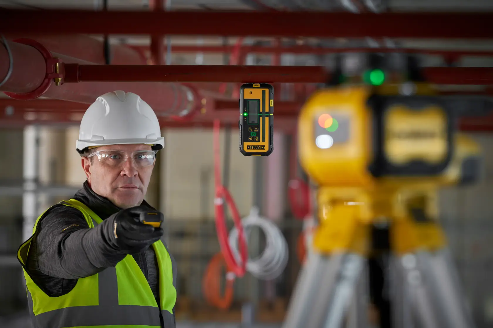 DEWALT DCLE15221G-QW, DCLE15221G laser, trépied, ouvrier équipé sur un chantier.