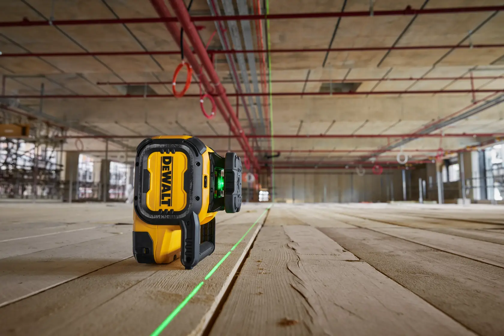 Outil photo laser vert DEWALT DCLE15221G-QW, DCLE15221G sur sol bois chantier.