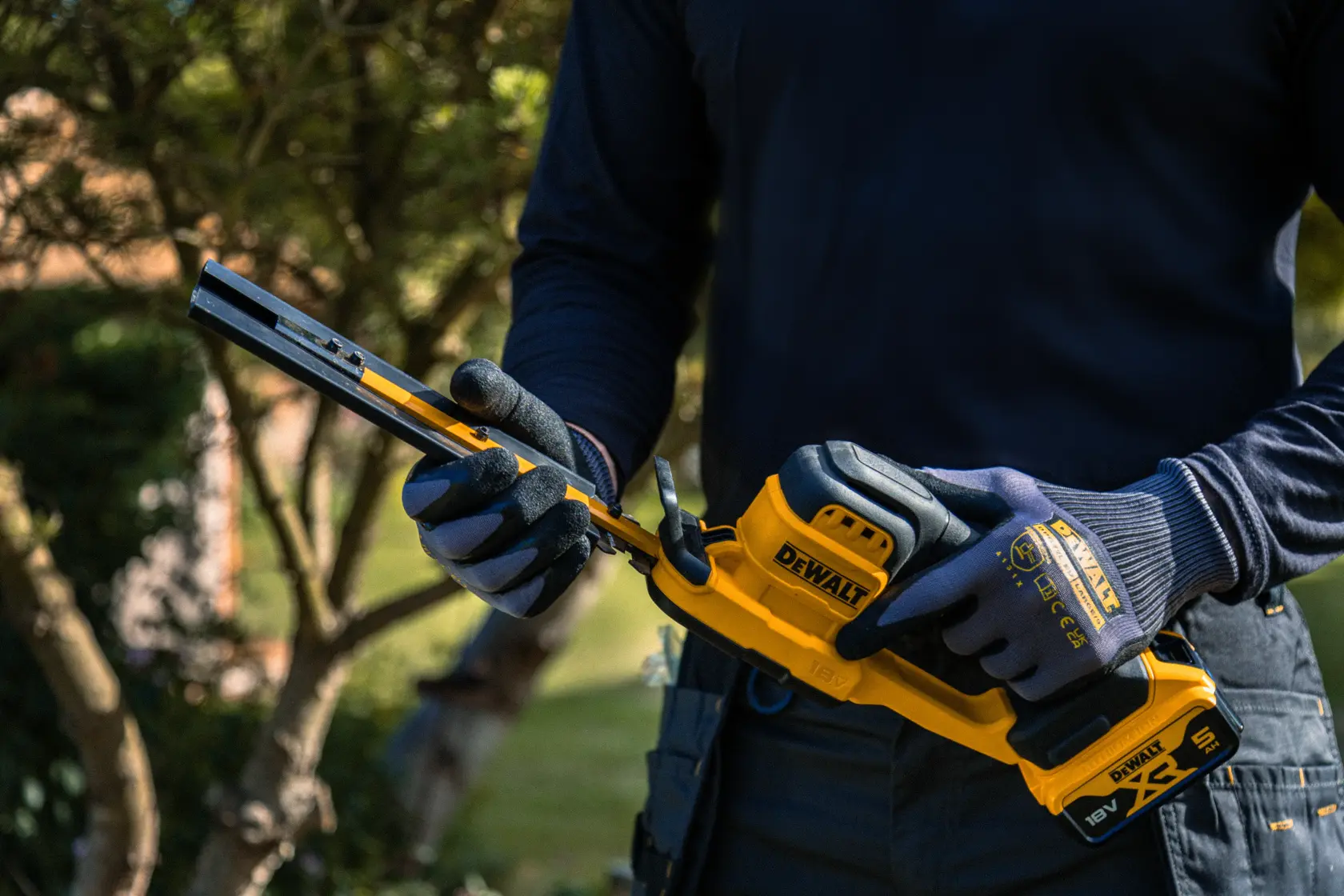 Outil DEWALT tenu dehors. SKUs: DCMHT520N-XJ, DCMHT520D1-QW, DCMHT520D1, DCMHT520N.
