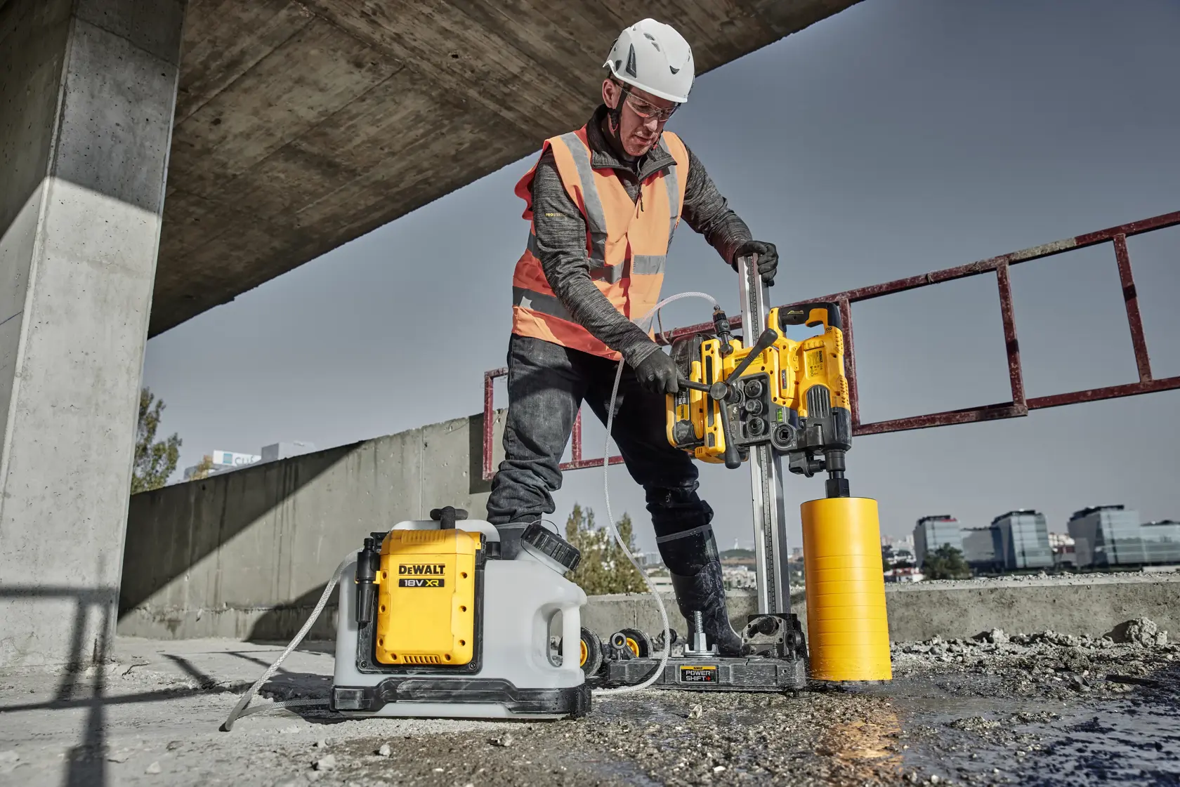 Vue rapprochée d'une perceuse à carottage DEWALT modèle DCPS151 montée sur un rail vertical, mettant en avant ses commandes utilisateur miroir et son mécanisme de verrouillage. Le texte superposé indique « COMMANDES UTILISATEUR MIROIR - VERROUILLEZ LA PERCEUSE À CAROTTE EN PLACE ».