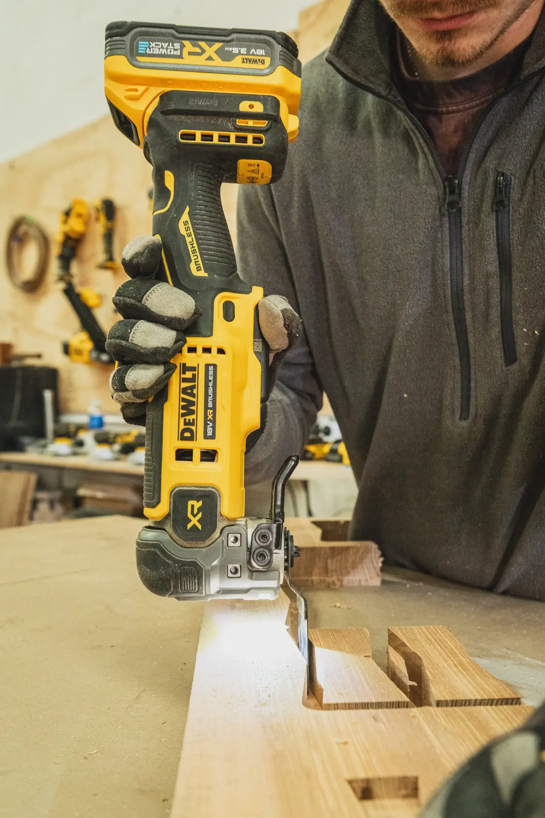 Personne utilisant une scie sauteuse sans fil DEWALT pour couper du bois sur un établi.
