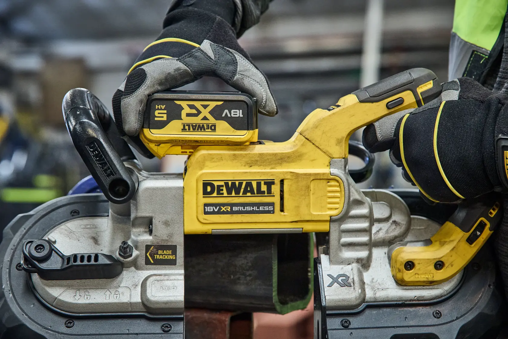 DEWALT DCS374N, DCS374N-XJ scie sans fil utilisée, mains gantées. Catégorie photographie.
