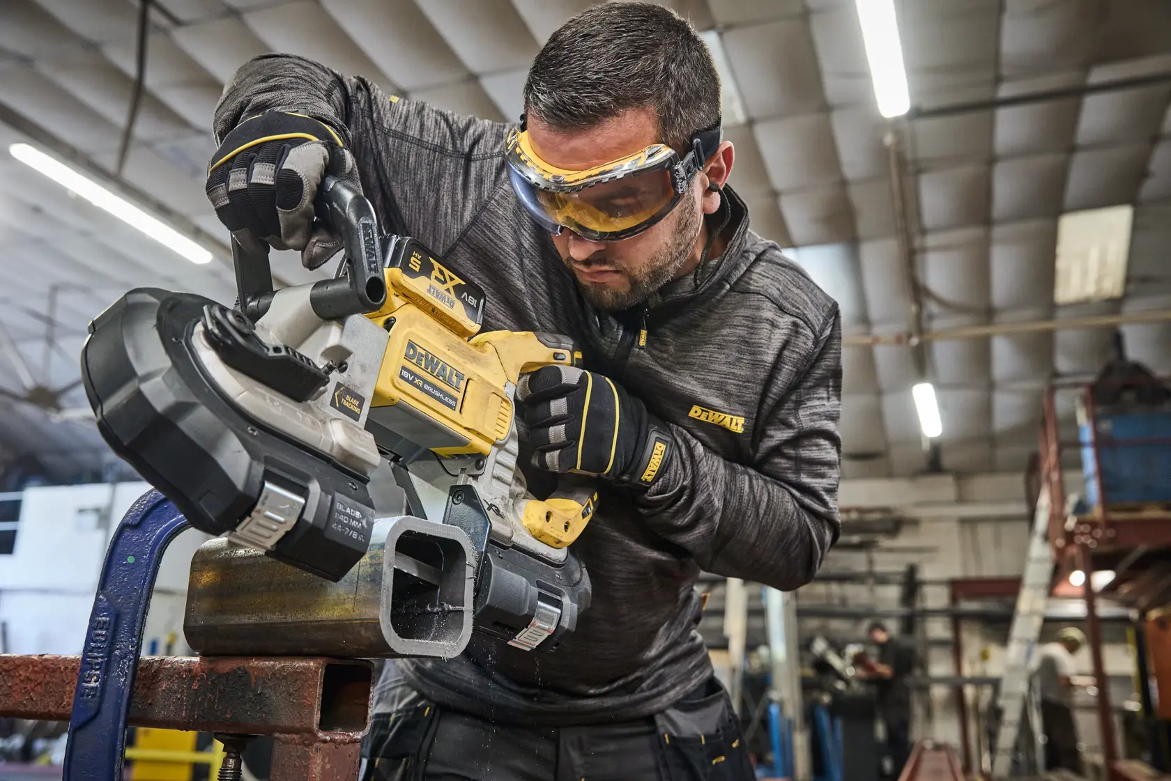 DEWALT DCS374N, DCS374N-XJ scie à ruban utilisée sur tube métal. Catégorie photographie.