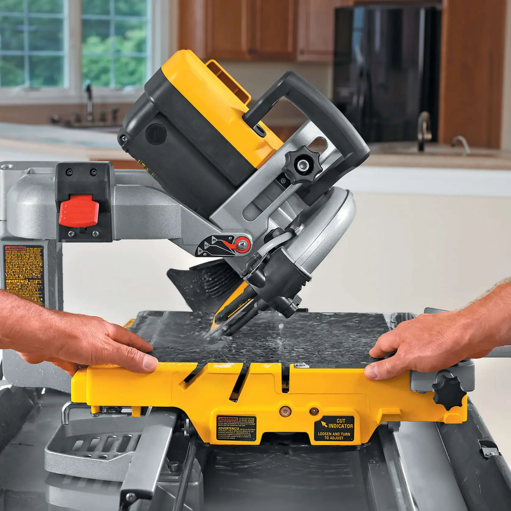 Des mains guident une scie à carrelage DEWALT coupant une dalle en pierre. Angle et sécurité réglables visibles.