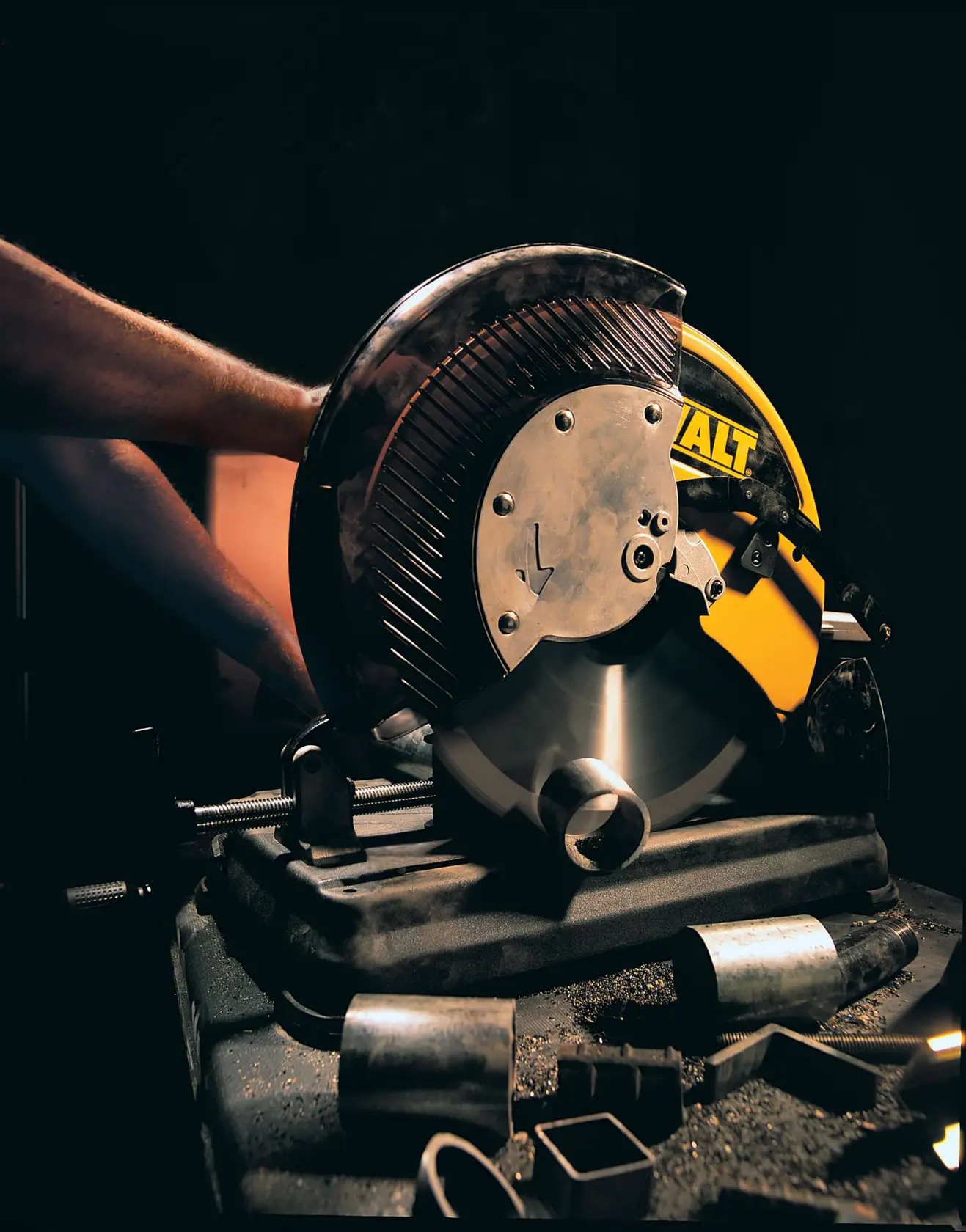 Image d'une scie à découper le métal DEWALT, modèle DW872, avec des caractéristiques indiquées telles que poignée ergonomique, clôture ajustable, grande capacité de coupe, étau à verrouillage rapide et facilité de transport vers et depuis les chantiers.