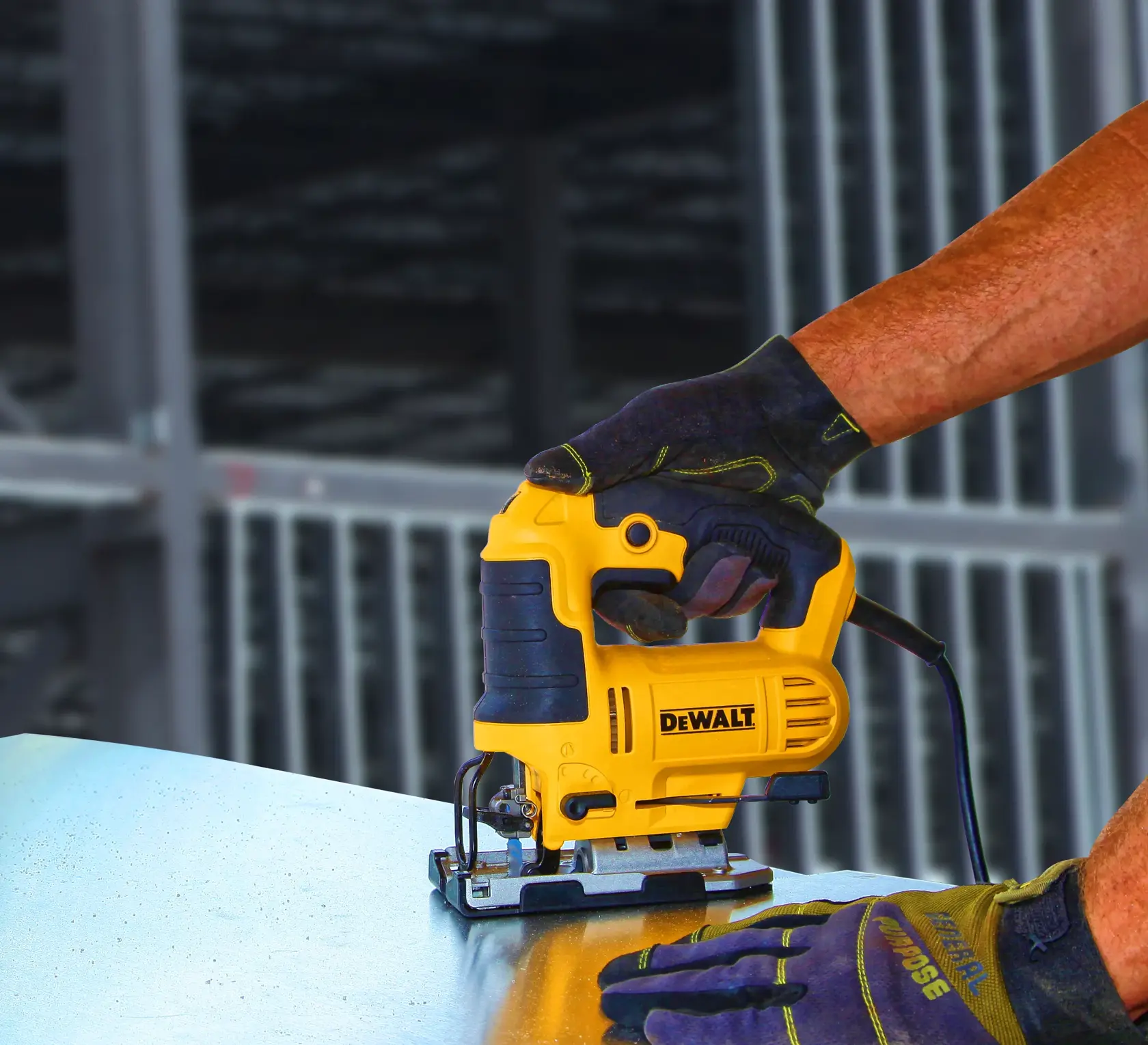 Une personne portant des gants utilise une scie sauteuse jaune et noire DEWALT pour couper une feuille de métal.