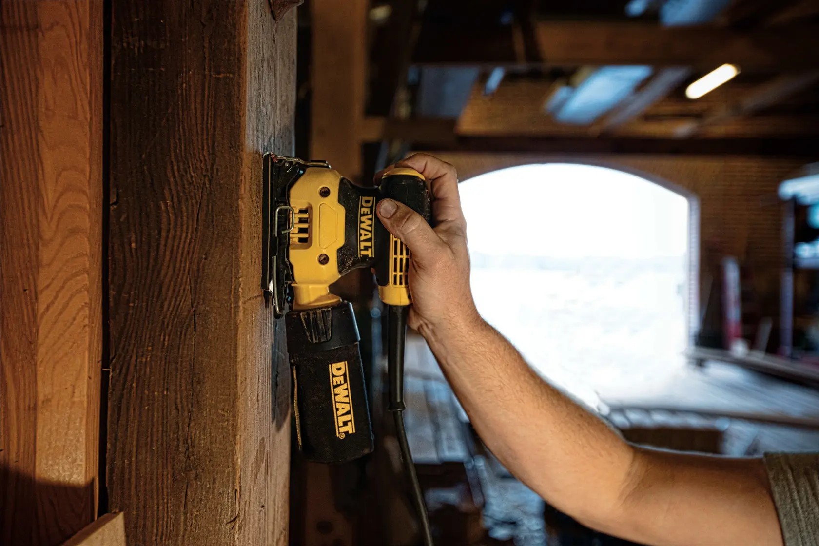 DEWALT electric sander kit with a yellow and black sander, dust bag, additional sanding pad, and a black carrying case with the DEWALT logo.
