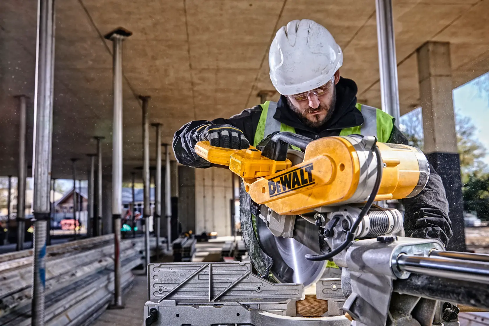 A DEWALT DWS780 sliding compound miter saw with a yellow and black design, featuring a circular blade, dust collection bag, and adjustable fence on a metal base.